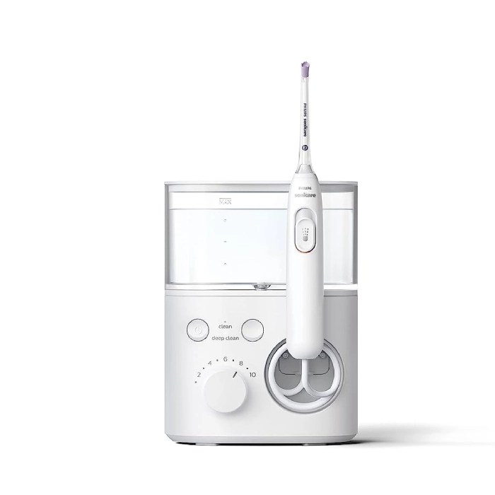 A white electric toothbrush sitting on top of a table.