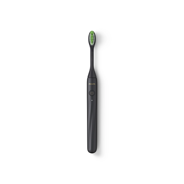 A black toothbrush with green bristles on top of it.