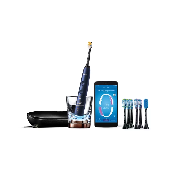 A smart phone and some tooth brushes are next to an electric toothbrush.
