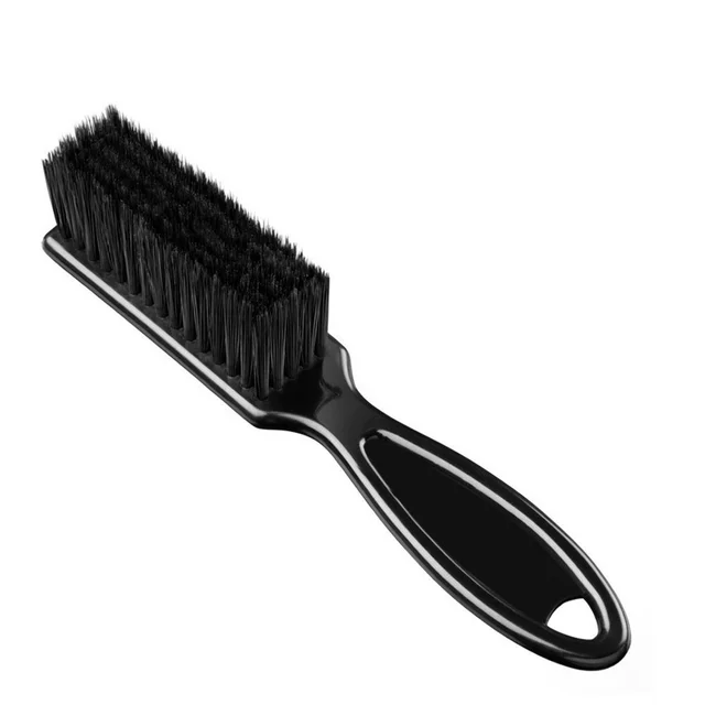 A black brush is sitting on top of the floor.